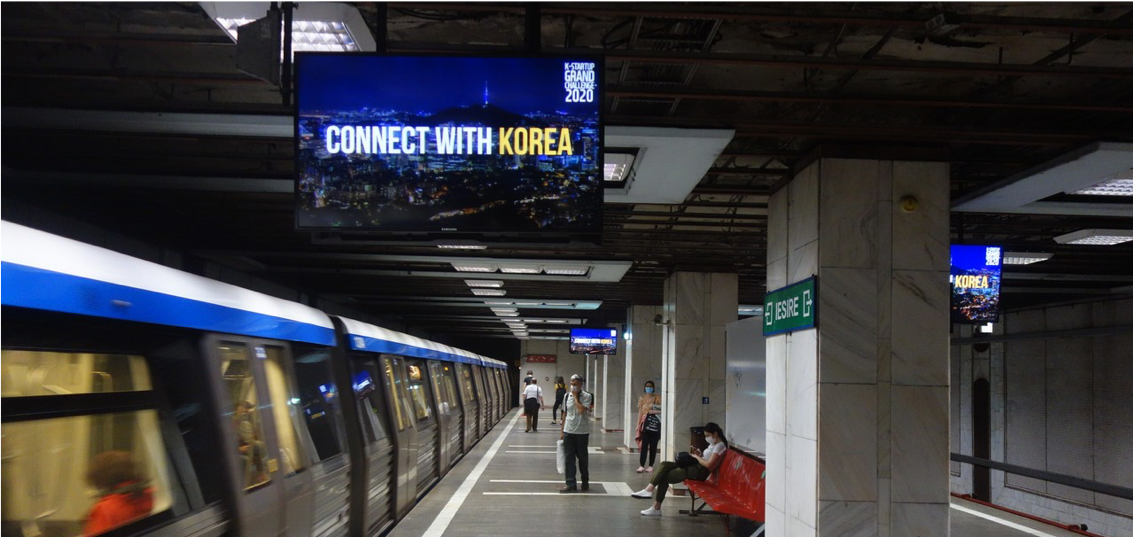 Underground subway platform with 'Connect with Korea' displayed on a large screen, encouraging engagement with Korea.