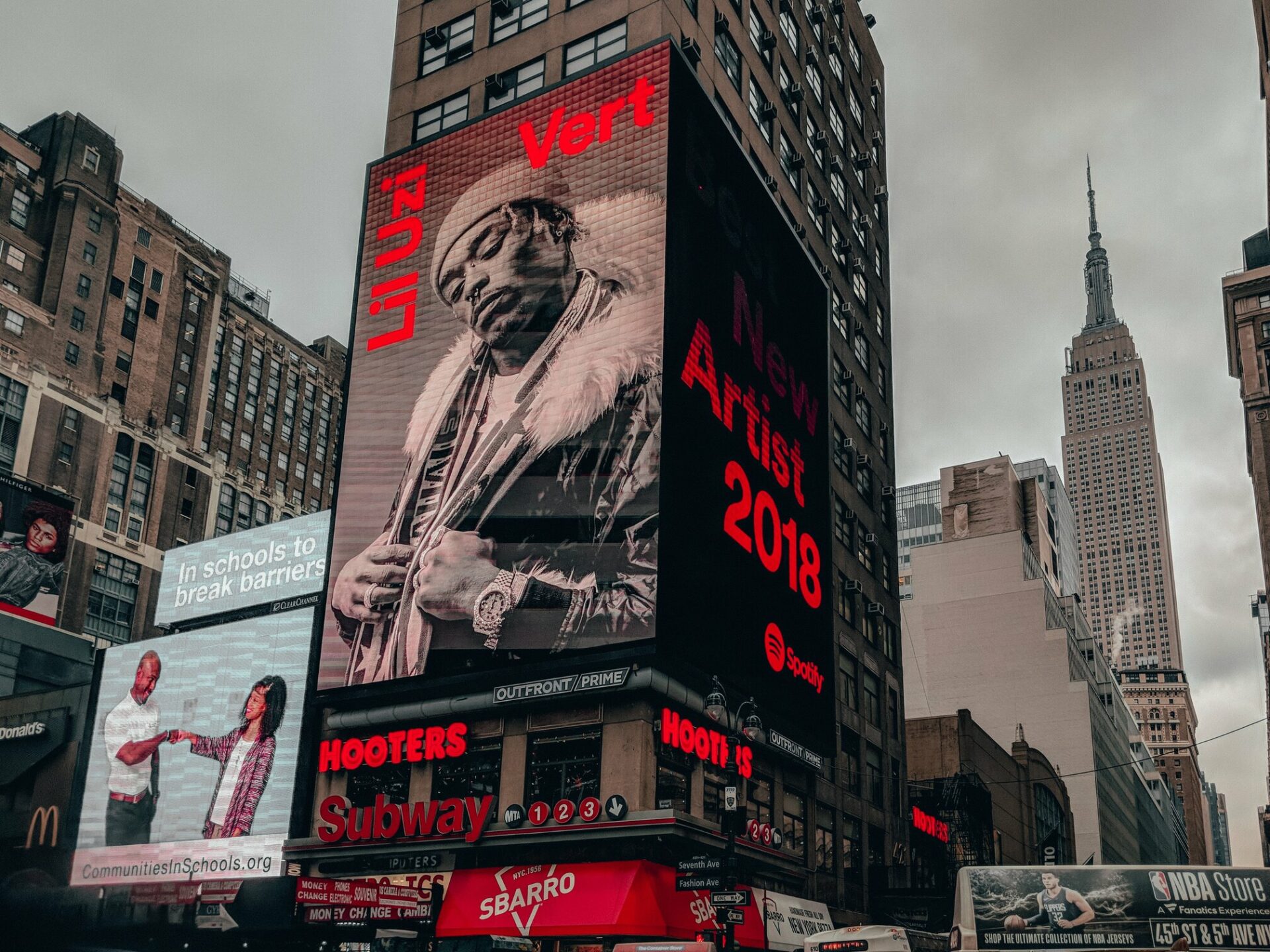 Digital billboards lighting up a busy urban street at night