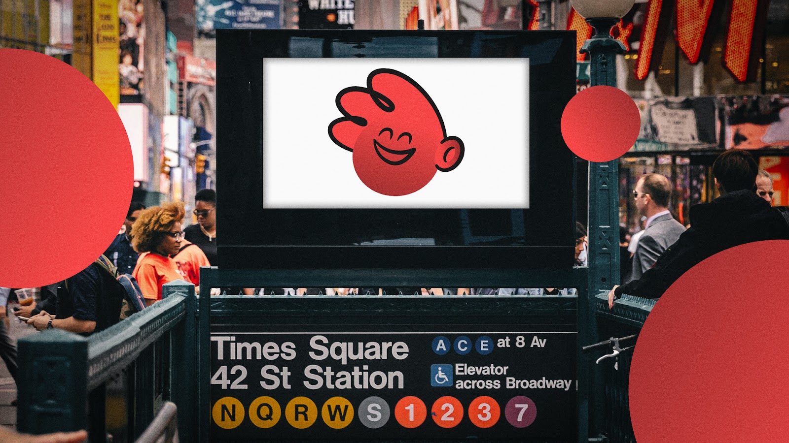 A digital screen at Times Square 42nd Street subway station displaying a smiling red cartoon mascot, with branded red circle design elements overlaid