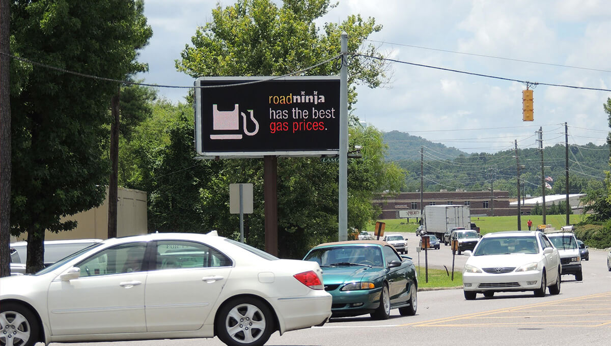 Digital out-of-home billboard displayed along a busy roadway in Alabama