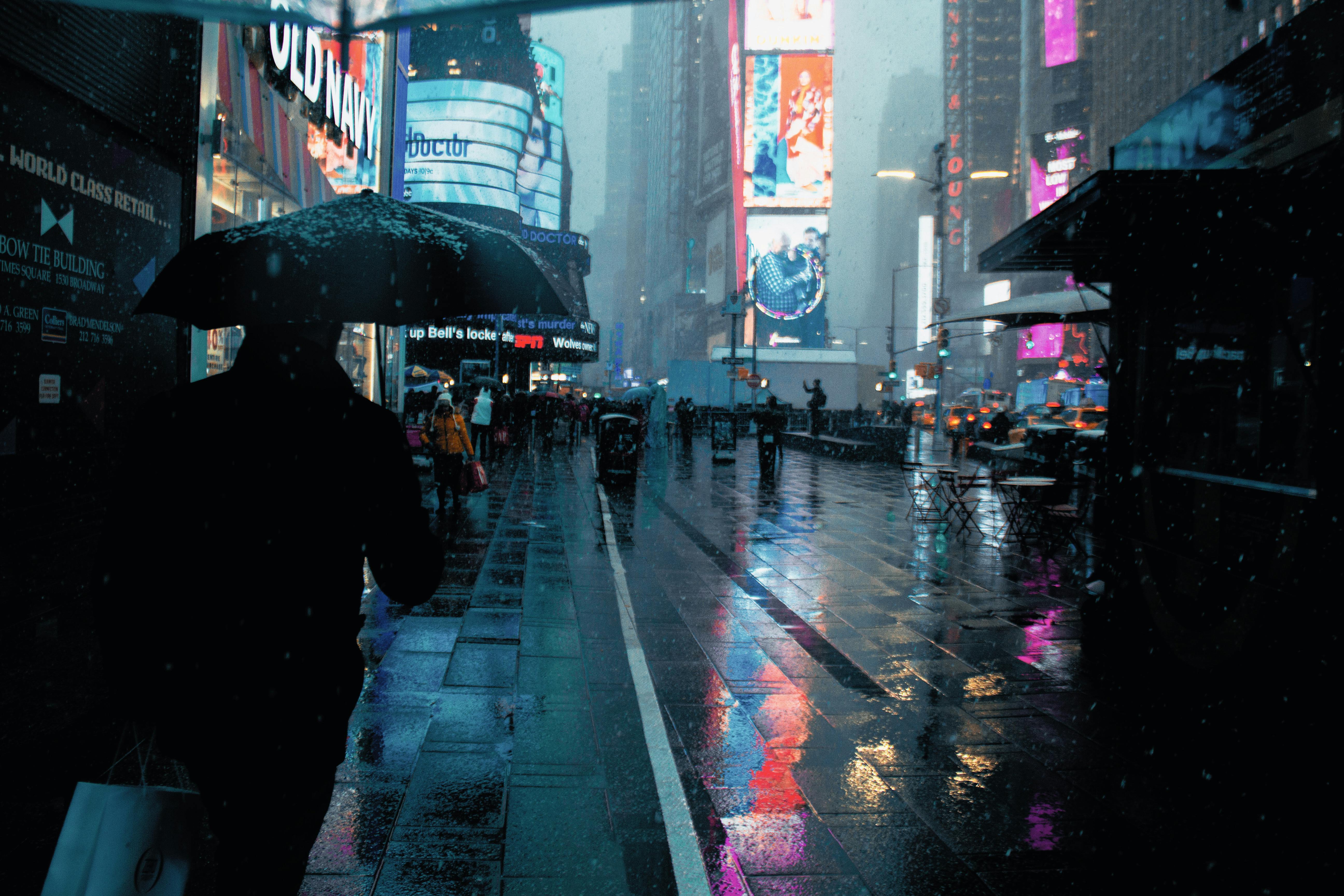 walking on rainy city street with wet pavement reflecting urban lights